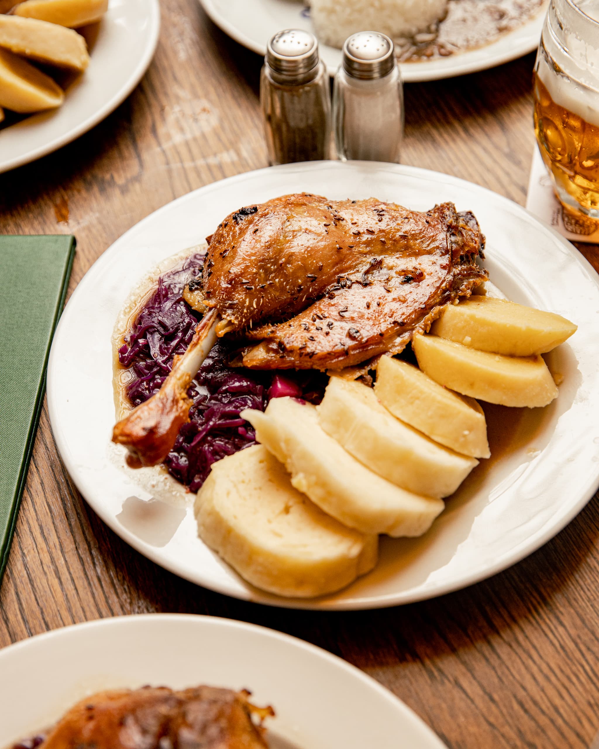 Talíř s pečeným husím stehnem, červeným zelím a houskovým knedlíkem servírovaný v některé z restaurací Ambiente.