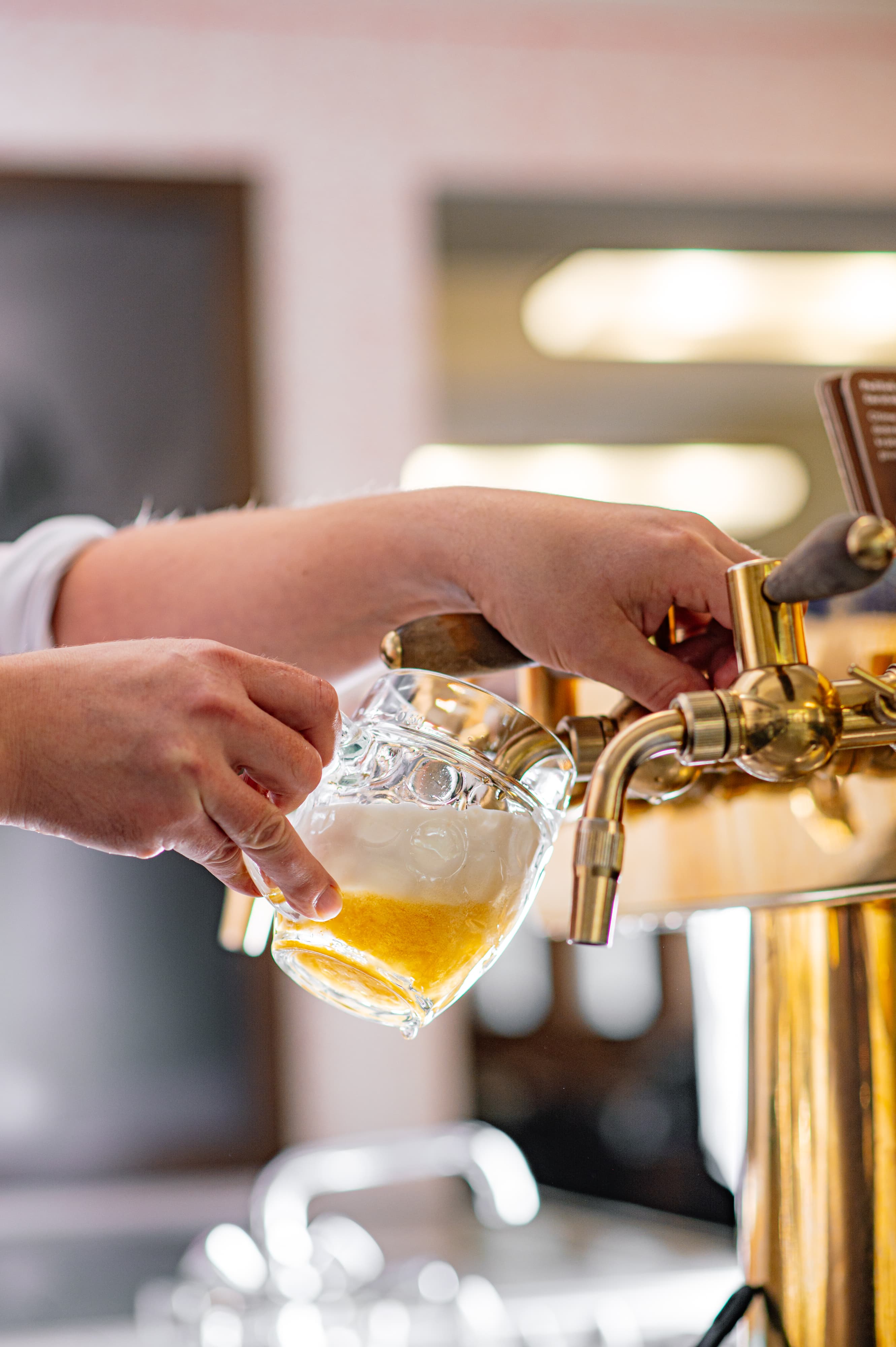 Půllitr nefiltrovaného Pilsner Urquell s bohatou pěnou postavený na stole v Lokále.